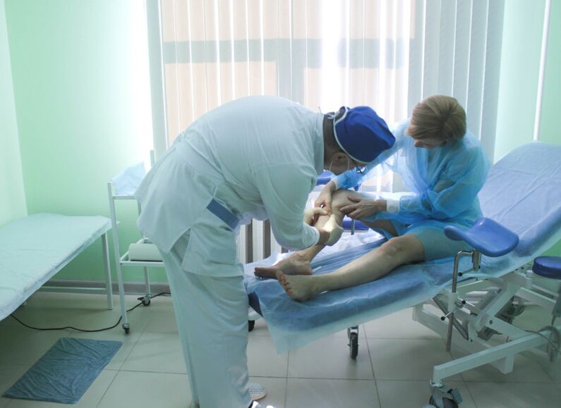 Chirurgas, prieš atlikdamas operaciją, apžiūri paciento venas.